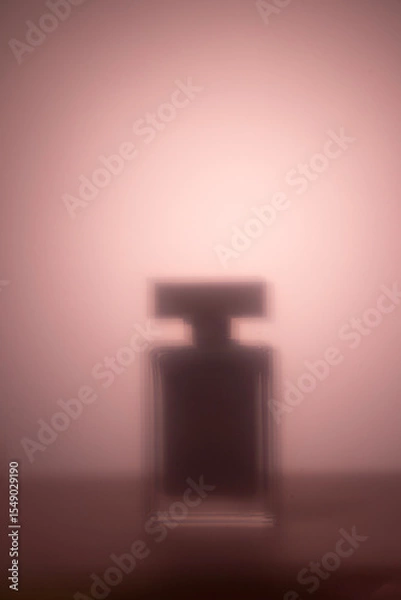 Fototapeta A blurred silhouette of a perfume bottle set against a soft pink gradient background abstract fragrance and beauty concept