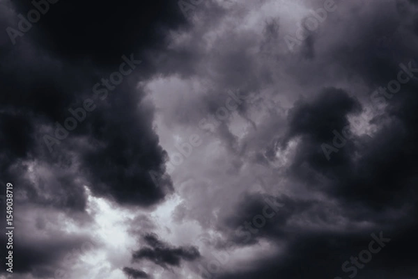 Fototapeta A stormy sky filled with ominous, dark heavy low clouds, creating a dramatic scene. Moody shot of a gloomy grey sky filled with swirling, storm clouds. Stormy weather. Before storm, rainstorm.