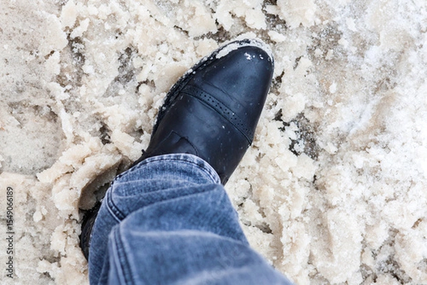 Obraz Winter Footwear in Slushy Mud and Melting Snow: A Close-Up of Resilient Style and Seasonal Challenges.