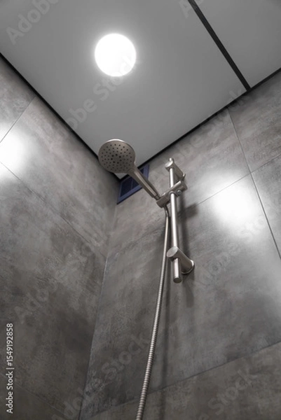 Obraz Modern shower head hanging elegantly in a contemporary bathroom, highlighting its sleek design and functionality against a stylish backdrop of gray tiles, enhancing the space's luxury and comfort