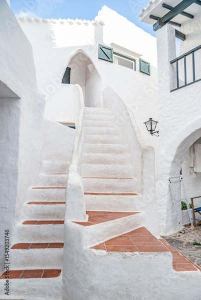Fototapeta White Mediterranean Architecture With Curved Staircase in Binibeca Vell. Menorcan Fishing Village, Terracotta Steps, Whitewashed Walls, Spanish Architecture