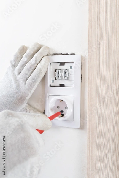 Fototapeta installation of a light switch socket after renovation on a white wall