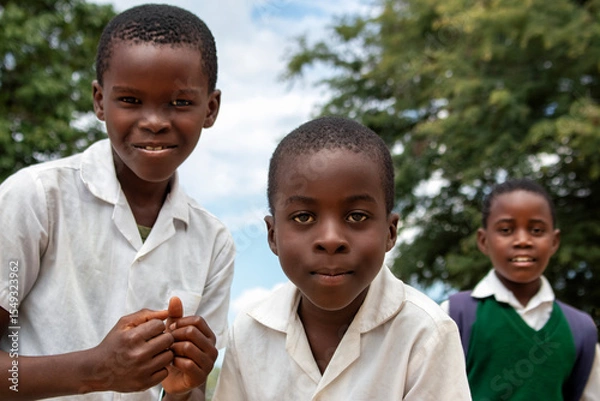 Fototapeta Premium close-up of happy African schoolchildren in uniforms, laughing together outdoors. A powerful and uplifting image capturing real joy, childhood, and cultural connection.