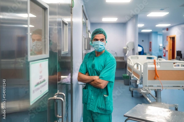 Fototapeta Surgeon in green scrubs waiting outside the operating room