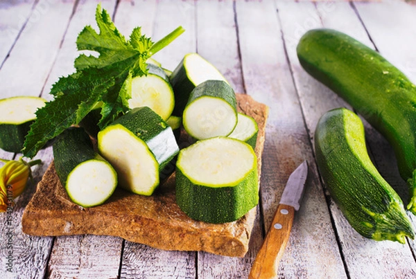 Obraz Slicing zucchini on a cutting board. Ripe zucchini. Top view, horizontal.