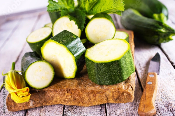 Obraz Slicing zucchini on a cutting board. Ripe zucchini. Top view, horizontal.