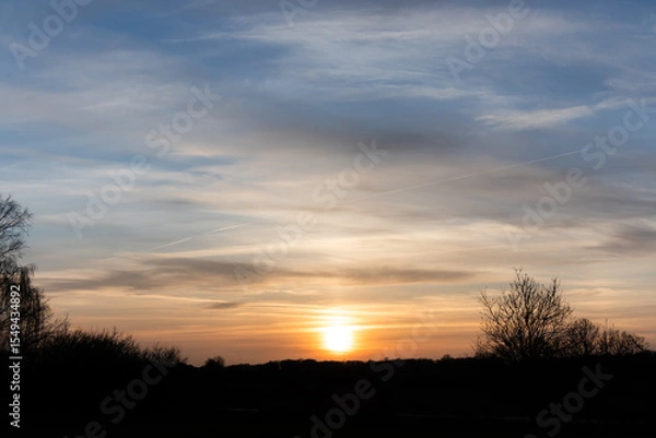 Fototapeta Sunset with a beautiful cloud pattern and a nature silhouette