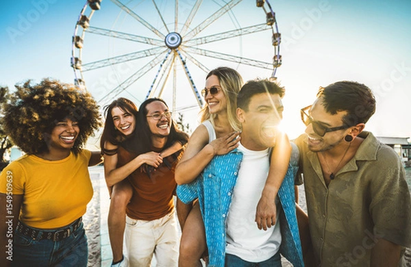 Fototapeta Multiracial friends having fun walking in front of ferris wheel at summer vacation - Friendship concept with guys and girls hanging outside on a sunny day - Summertime holidays life style concept