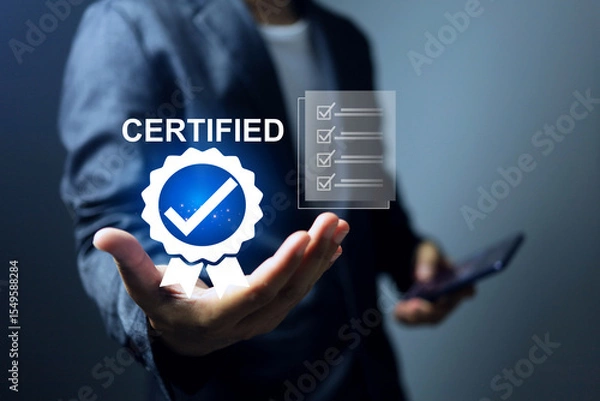 Fototapeta Businessman holding a certification with check mark on the certificate document system that has certified to a quality standard passed audit according to industry standards