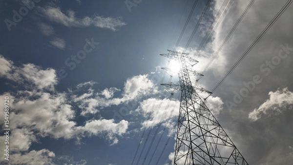 Fototapeta High voltage power tower Electrical pole structure blue sky background. Transmission energy cable line.