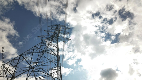 Fototapeta High voltage power tower Electrical pole structure blue sky background. Transmission energy cable line.