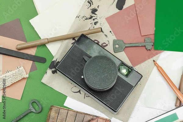 Obraz Flat lay with vintage camera, cassette, notebook, key and research tools on green background