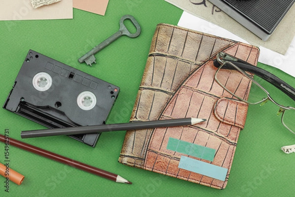Obraz Flat lay with vintage camera, cassette, notebook, key and research tools on green background