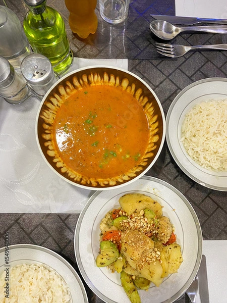 Fototapeta Paraguayan cuisine served in hotel. Local food of sopa de verduras (vegetable soup), panache de verduras (mixed vegetable dish), and rice on dining table, flat lay top angle vertical shot.