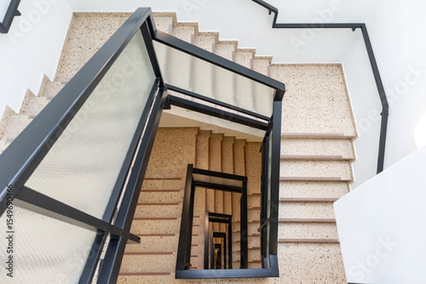 Fototapeta Empty Spiral Square Stone Staircase in a European Residential Building