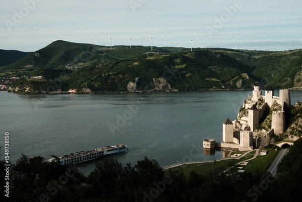 Obraz Panoramic scene of Golubac Fortress and Danube River with a cruise ship passing by. A popular tourist destination in Serbia