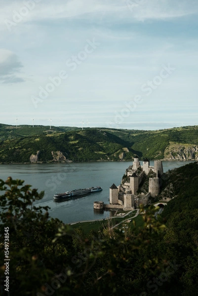 Obraz Panoramic scene of Golubac Fortress and Danube River with a cruise ship passing by. A popular tourist destination in Serbia