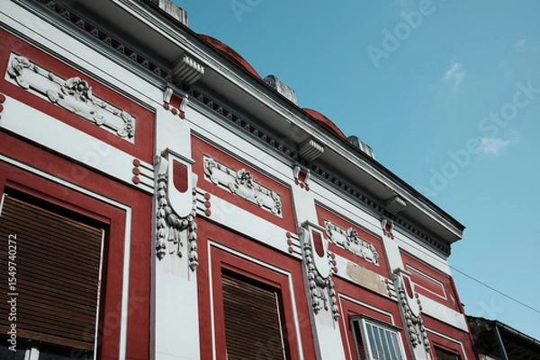 Obraz Close-up of ornate architectural details on a historic red and white building in Vrsac town, Serbia
