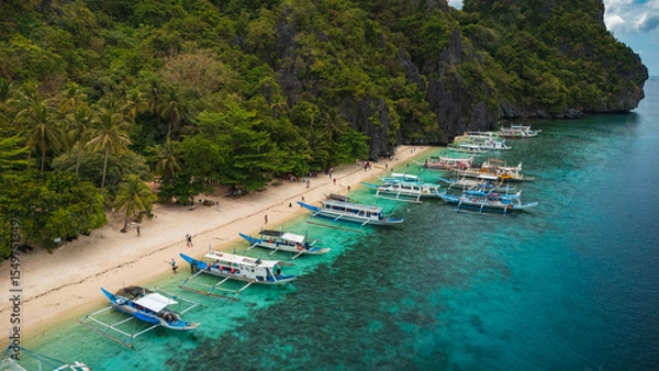 Obraz Aereal view of Colorful Bangka Boats Docked on the Crystal-Clear Waters and Coral Reefs of Entalula Island with a beautiful beach with people in El Nido, Palawan, Philippines