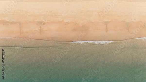 Obraz Bird's eye top aerial view of woman relaxing in sandy beach in the pristine turquoise shoreline and sweeping coastal landscape of Nacpan Beach in El Nido, Palawan, Philippines