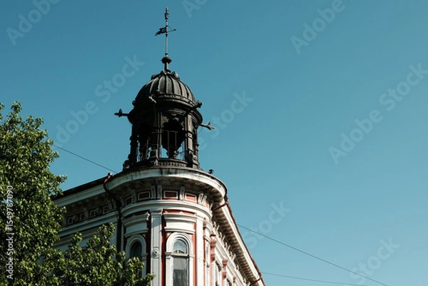 Obraz Historic red and white building with ornate tower and metal dome in Vrsac, Serbia, under clear blue sky.