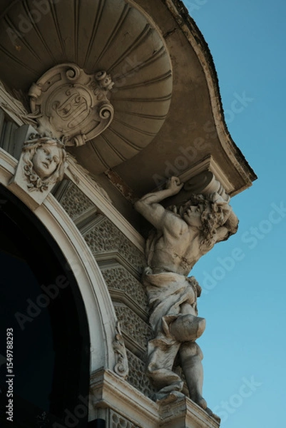 Obraz Stone figure holding a cornice on an ornate building in Vrsac, Serbia, with symbolic facial features and scroll design.