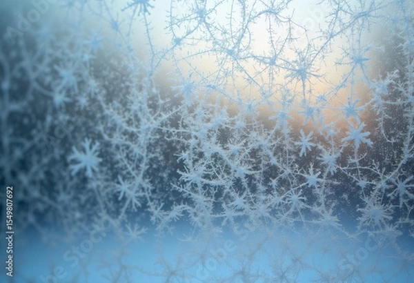 Fototapeta Frosty ice crystals forming intricate winter patterns on a cold window pane.