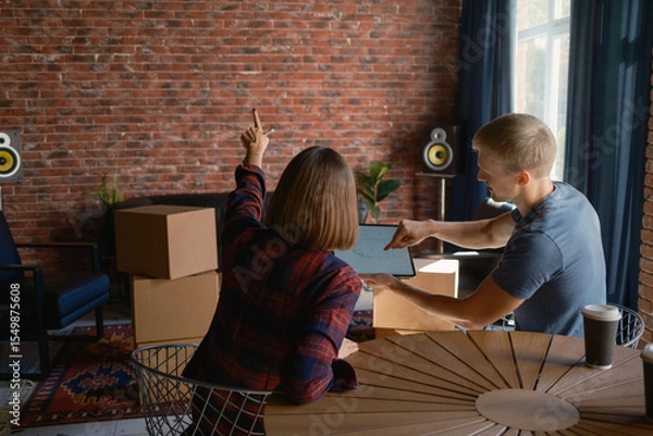 Obraz Two people planning interior arrangements in a loft-style apartment after moving in
