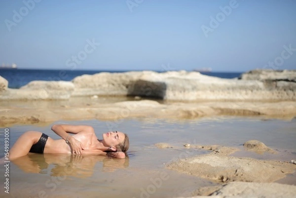 Obraz woman lying in a natural pool at the seaside