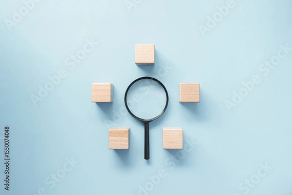 Obraz Magnifying glass surround by empty wooden block on pastel blue background. Business concept on business target, strategy development, search for idea and focus.