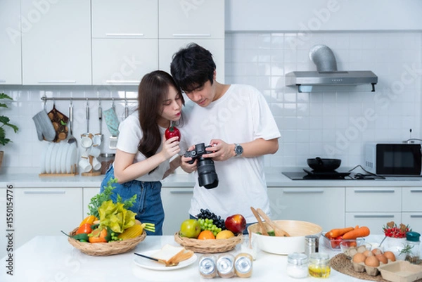 Obraz Happy portrait of loving young asian of having fun standing Take a photo after enjoy cook cooking with vegetables, meat, bread while standing on a kitchen Condo life or home