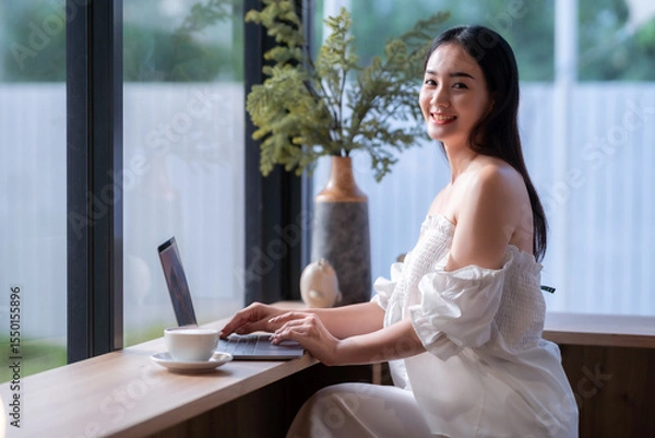 Obraz Asian freelance people business female talking making using casual working with laptop computer and coffee at home in the living room indoors artificial rose bouquet of red and pink roses rose vase