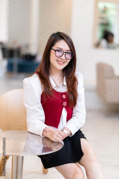 Obraz Portrait of beautiful happy Smiling asian woman relaxing sitting in cafe interior in coffee shop background