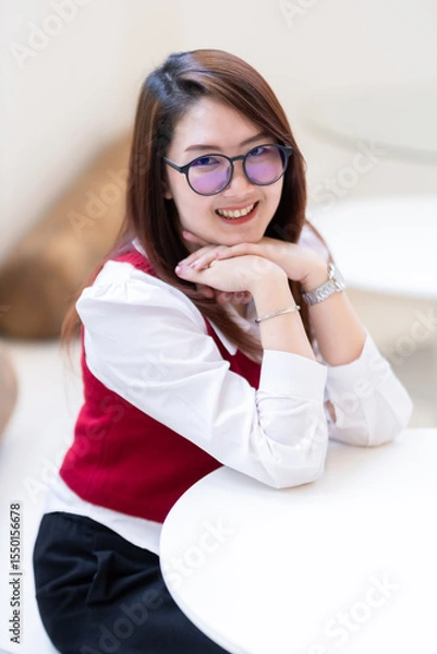 Obraz Portrait of beautiful happy Smiling asian woman relaxing sitting in cafe interior in coffee shop background