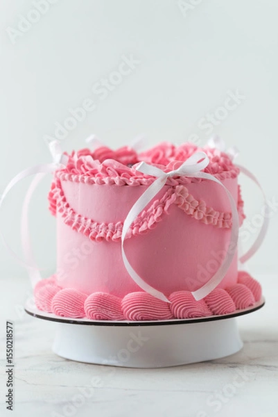 Fototapeta Delicate lambeth style birthday cake with pink cream cheese frosting decorated with cream tracery and happy birthday text on top. White background