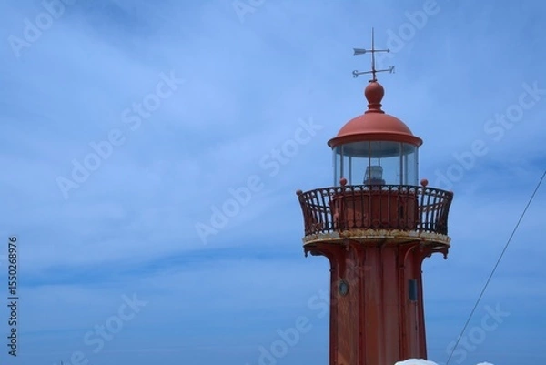 Fototapeta Red iron lighthouse structure, state owned historical navigation aid atop the Fort of Saint Catarina in Figueira da Foz Portugal