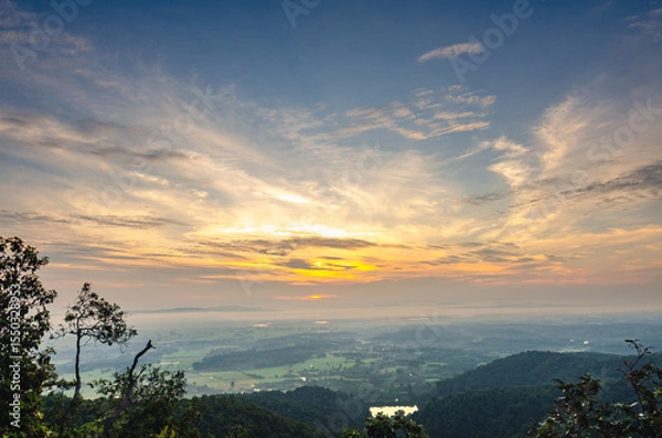Obraz Beautiful view of the sunrise, light through the clouds on the mountain top, reflecting on the water in the rice fields, rural area of ​​Phayao Province, Northern Thailand.