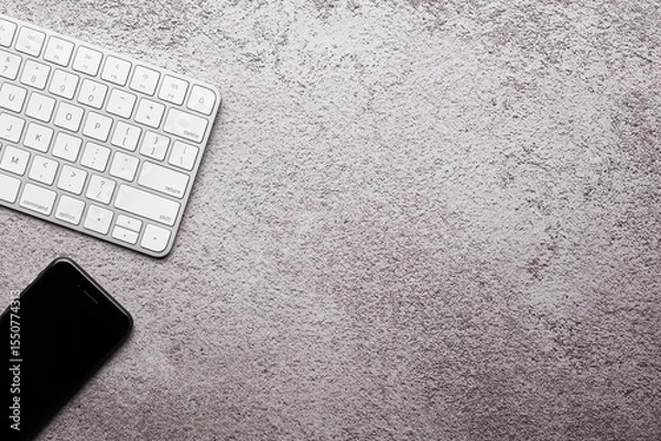 Obraz Smartphone and Wireless Keyboard on Textured Gray Surface