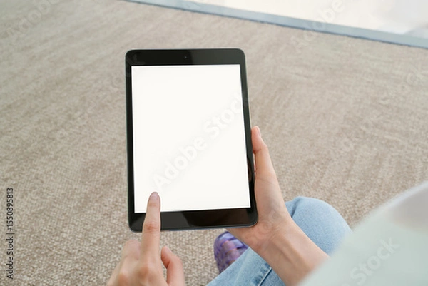 Fototapeta Hand holding digital tablet with blank screen for graphic display montage in the building area, mockup display for lifestyle and wireless technology.