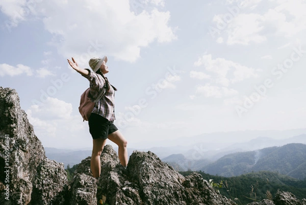 Obraz Woman hiker on top of mountain. Hiker with arms up on top of mountain successful young woman enjoying triumph. traveler exploring world. Hikers with backpacks relaxing. Sport and success concept.
