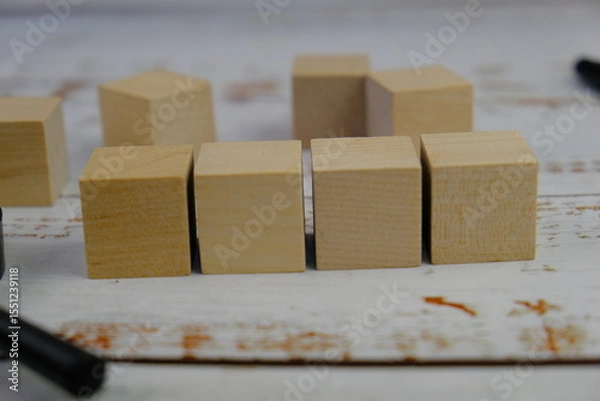 Fototapeta wooden blocks scattered on the wooden table with wooden figures as a people concept. 