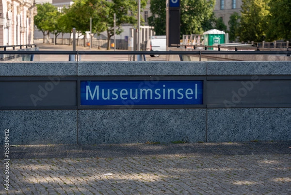 Fototapeta View of the Museum Island subway sign against a modern urban backdrop. The subway station is centrally located in Berlin and leads directly to Museum Island.