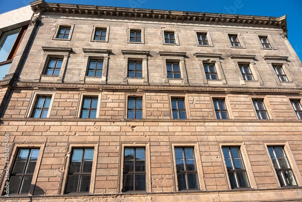 Fototapeta The historic building facade shows clear signs of war damage with visible bullet holes. The window structure and patina give the building character.