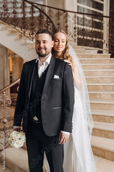 Obraz The bride and groom are on a beautiful staircase.