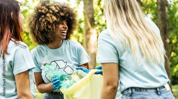 Fototapeta Group of volunteer cleaning picking up plastic litter in the park - Diverse group of people collect trash in the forest - Environmental protection, non profits organization and save the planet concept