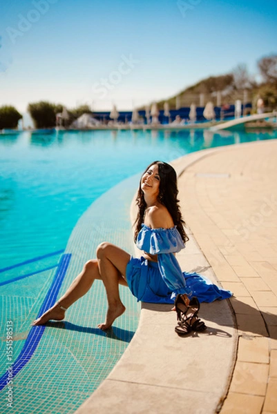 Obraz Beautiful woman sitting on the edge of the pool.