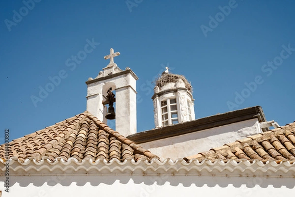 Obraz Storks Nesting atop Faro’s Historic Church