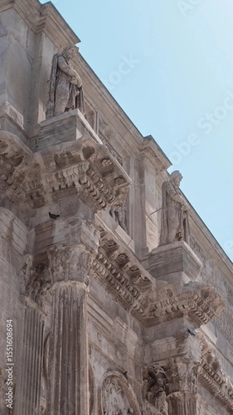 Fototapeta Ancient Architectural Details of a Grand Historical Building Featuring Statues and Ornate Columns During Daytime