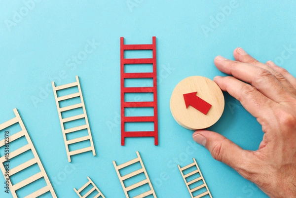 Fototapeta Hand holding cube with red arrow on textured paper background