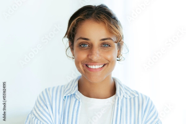 Obraz Close-up portrait of a smiling pretty blue-eyed brazilian woman. Confident and friendly young adult female with natural look, wearing casual clothes and expressing positivity and warmth at the camera